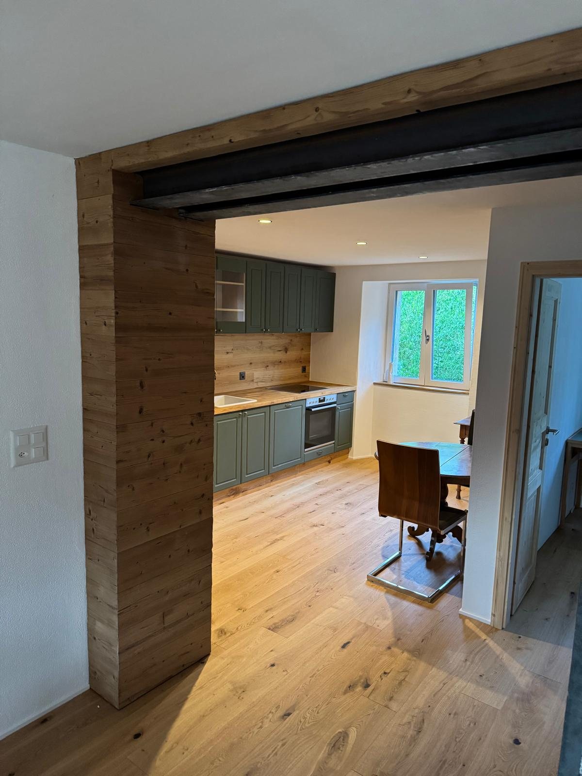 Detail der fertigen Küche mit Holz und grünen Fronten